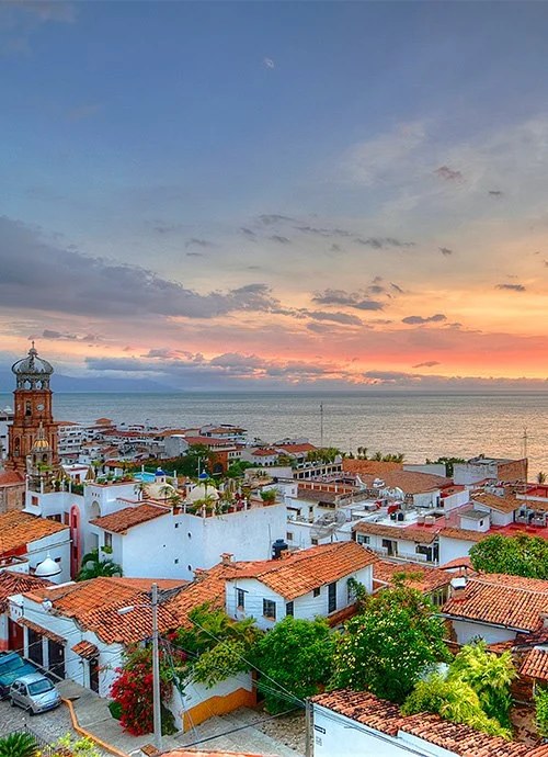 Terracotta rooftops of Puerto Vallarta's old town at sunset, looking over Banderas Bay